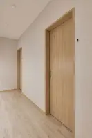 화이트와 우드톤의 미니멀한 시술실 복도